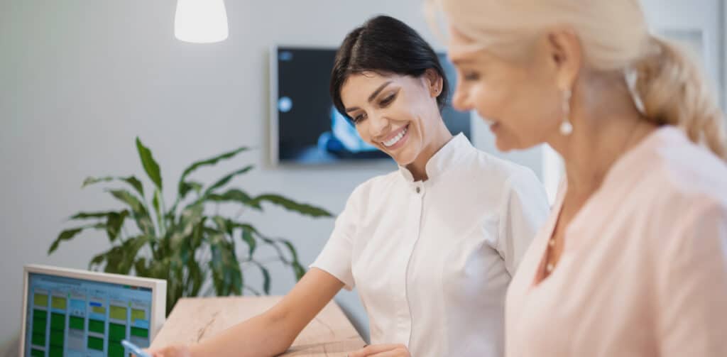 woman at dentists choosing options for artificial teeth