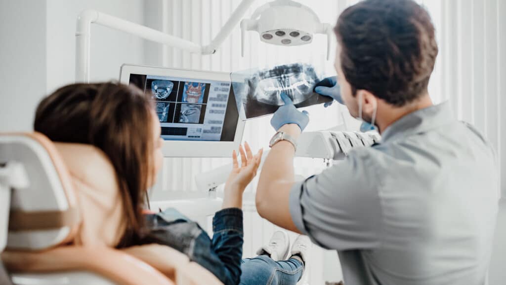dentists showing patient x ray for wisdom tooth removal dental surgeries