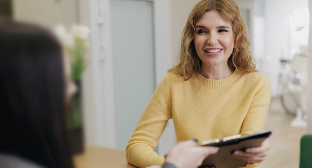 woman at dentists reception and factors that influence root canal treatment duration