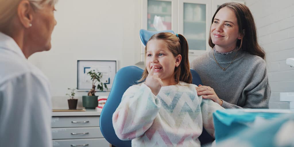 Girl and mother sat in dentists char dental exam checklist