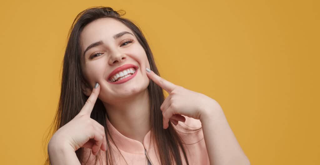 woman smiling longevity of bonding vs veneers difference