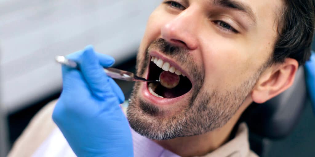 man at dentists sat in chair first dental appointment what to expect